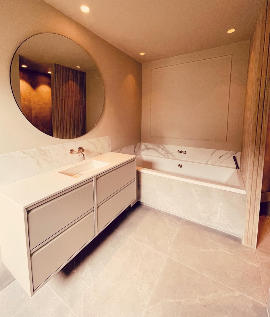 Badkamer met rond spiegel en marmerlook