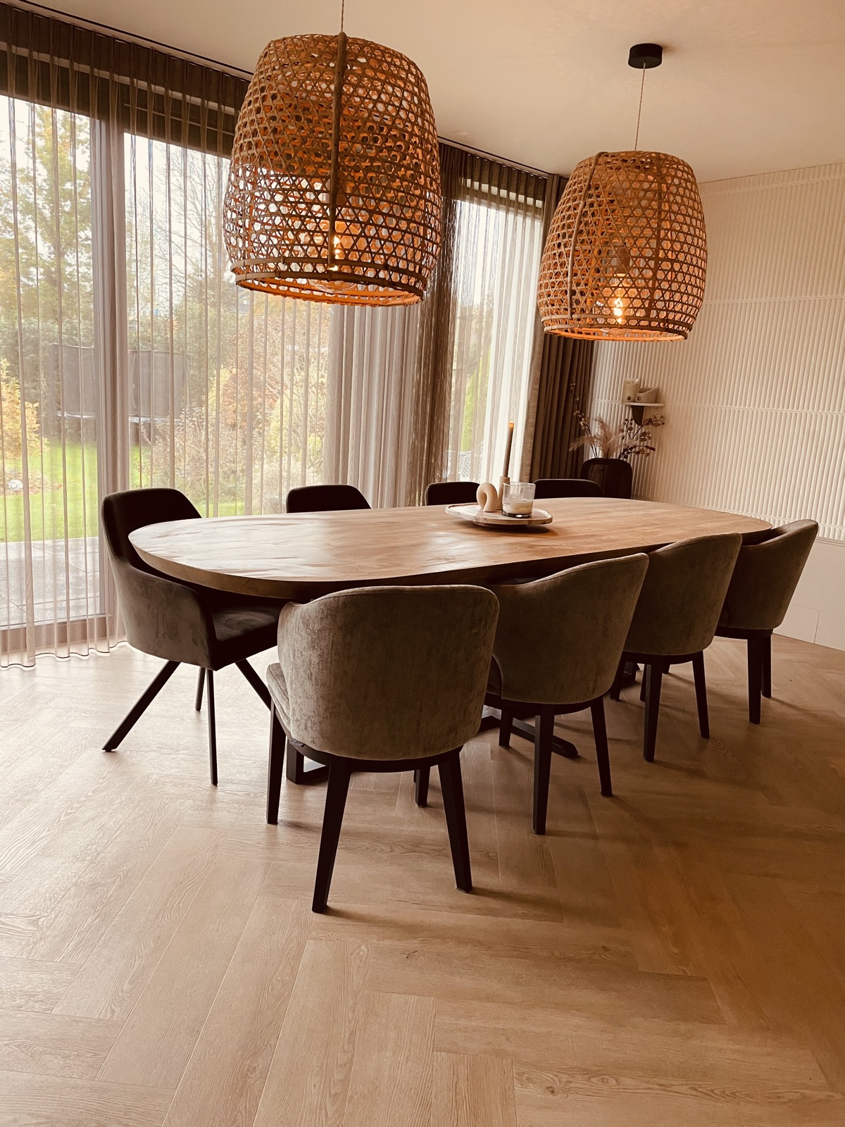 Door LEUK interieuradvies ingerichte eetkamer met ovale tafel en rotan hanglampen